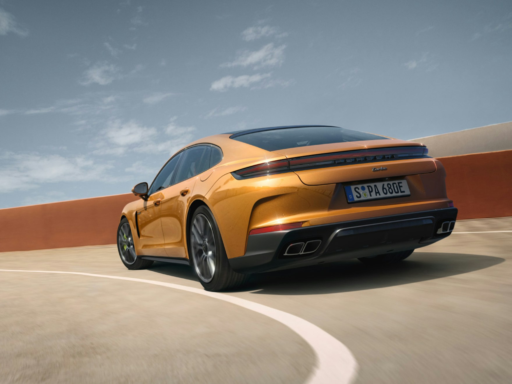 正在过弯的马德拉金属漆保时捷 panamera turbo e-hybrid 从后面看的