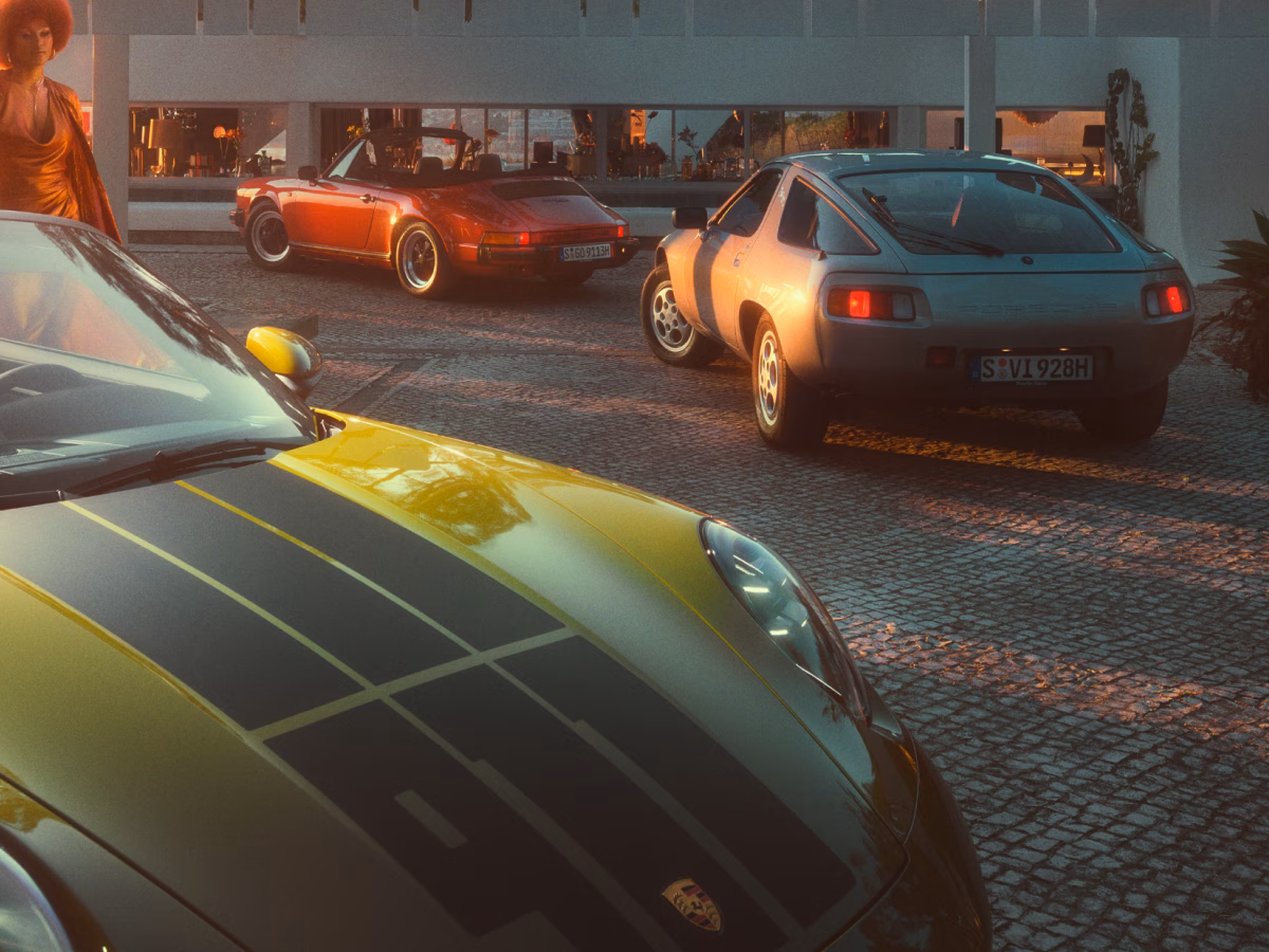 View of the bonnet of the Porsche 911 Spirit 70 in an Olive Neo paint finish. Classic Porsche models can be seen in the background.