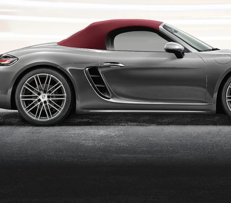 Side view of the Porsche 718 Boxster in Agate Grey Metallic with focus on the soft top.