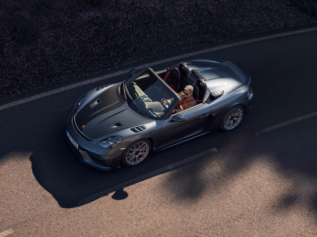 Blick von oben auf die Seite des Porsche 718 Spyder RS in Vanadiumgraumetallic mit Weissach-Paket. Sichtcarbonteile gut erkennbar.