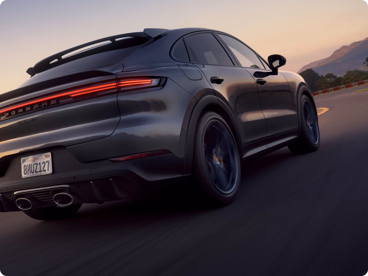 石英灰金属漆车身的保时捷 Cayenne Turbo GT 在赛道上行驶后端和侧面俯视图