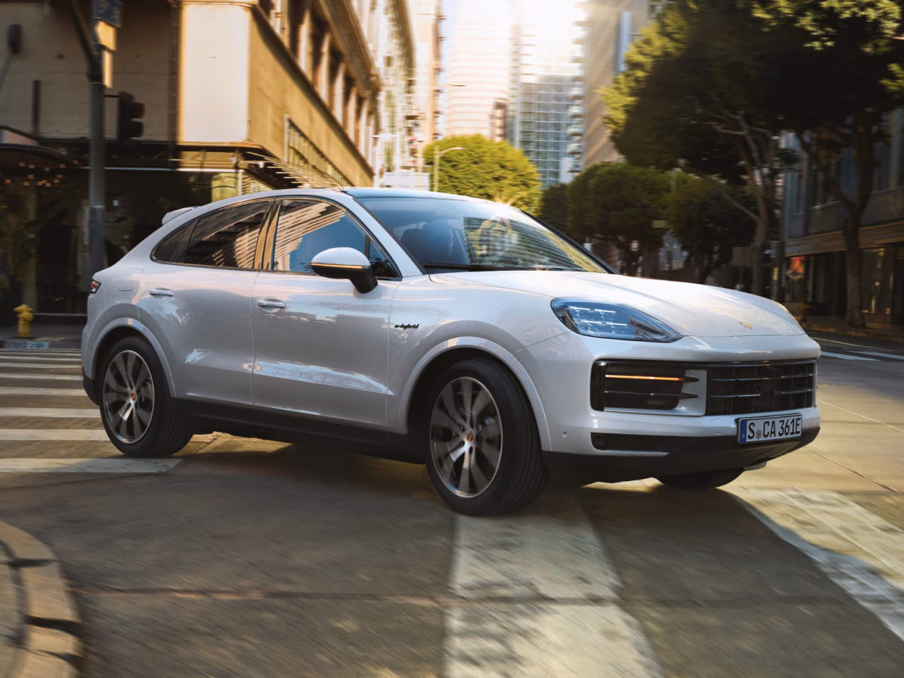 Porsche Cayenne S E-Hybrid Coupé in Carrara White Metallic driving along a motorway. Front and side views from the front.