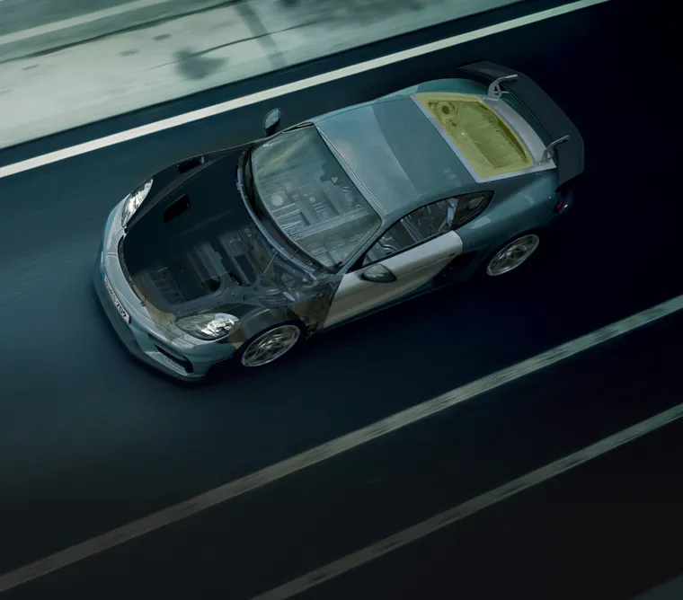 从高处俯瞰行驶中的保时捷 718 Cayman GT4 RS。车身部分透明。