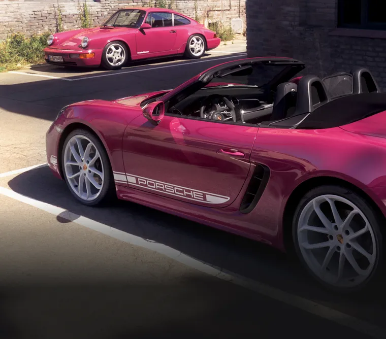 配备白色对比色组件的星光宝石红 Neo 保时捷 718 Boxster Style Edition 停在 911 Carrera RS 3.6 (964) 前方。侧面清晰可见