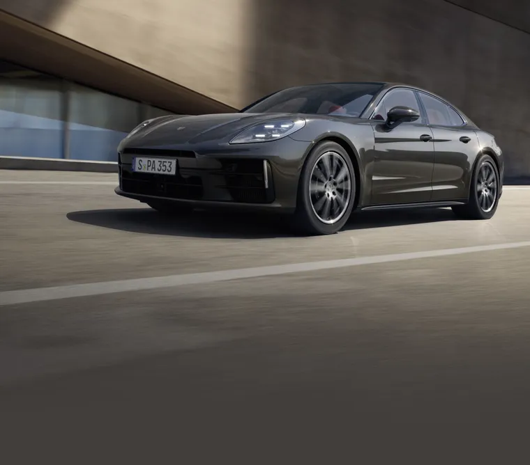 驶过一栋建筑的火山灰金属漆保时捷 Panamera 4 前侧视图
