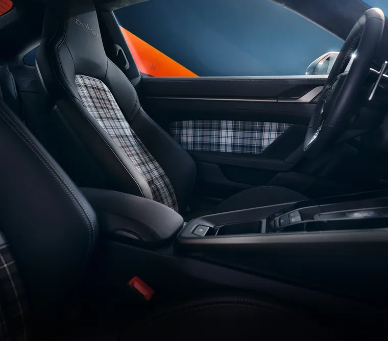 The interior of the Porsche 911 Turbo 50 Years with tartan pattern and elements in Turbonite is shown. 