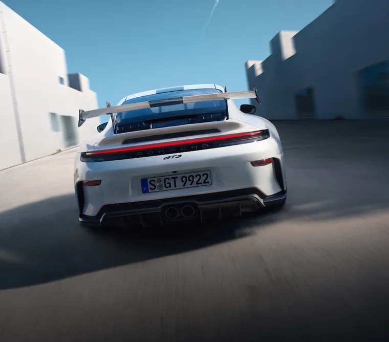 行驶中的白色保时捷 911 GT3 后视图。