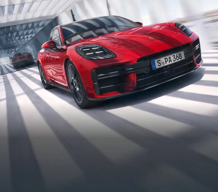 Porsche Panamera GTS in Carmine Red driving through the city. Front view from the front.