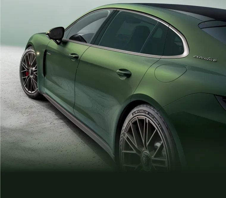 Porsche Panamera Turbo E-Hybrid Executive in Oak Green Metallic. Side view from behind.