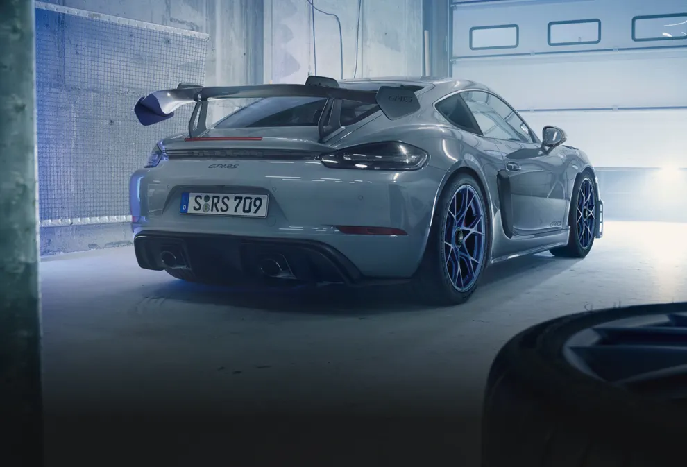 配备魏斯阿赫组件的极地灰保时捷 718 Cayman GT4 RS 停在车库中。采用织纹碳纤维后翼子板的尾部视图。