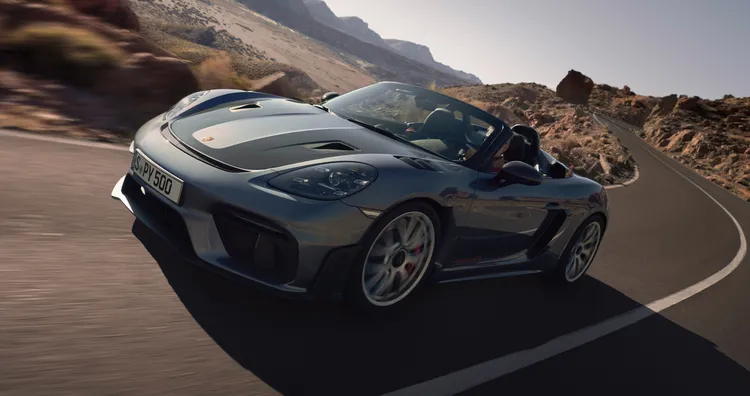 Porsche 718 Spyder RS in Vanadiumgraumetallic fährt durch Kurve. Sicht auf Front und Seite.