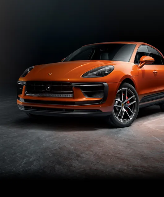 暗色背景前的帕派雅橙金属漆保时捷 Macan S 前视图和侧视图