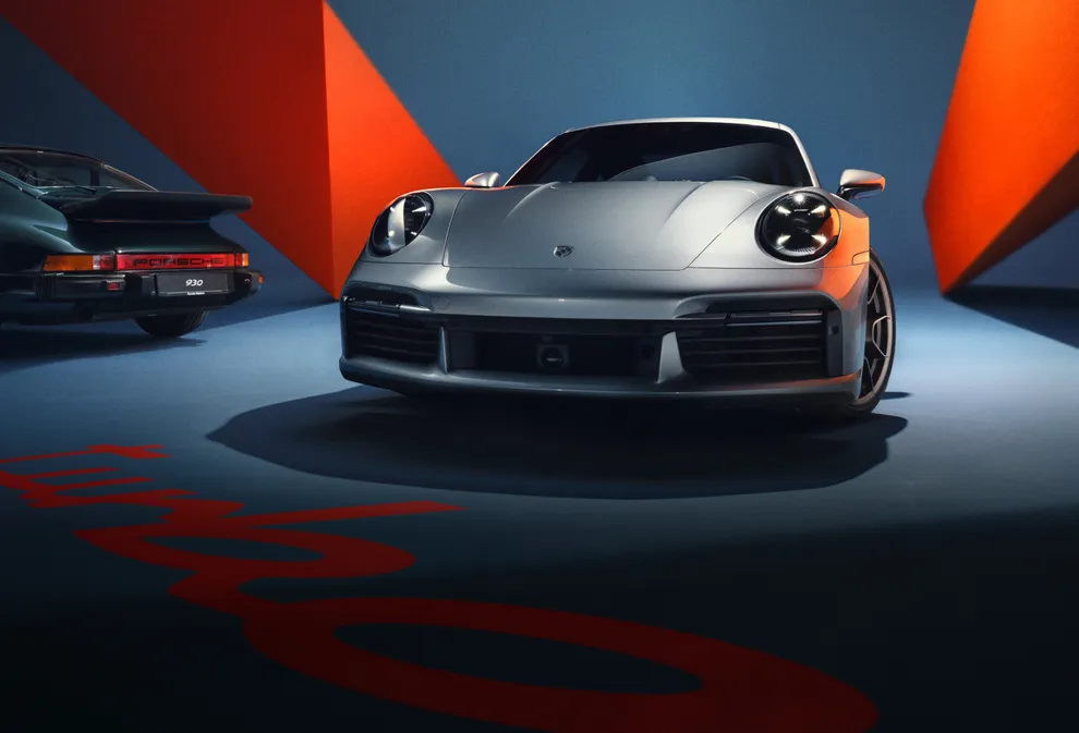 图片在蓝色背景下，从正面展示 GT 银金属漆保时捷 911 Turbo 50 周年纪念版车型 