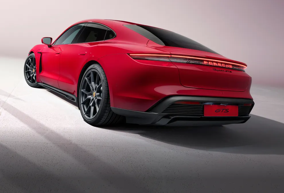 View of the rear and side of the Porsche Taycan GTS in Carmine Red.