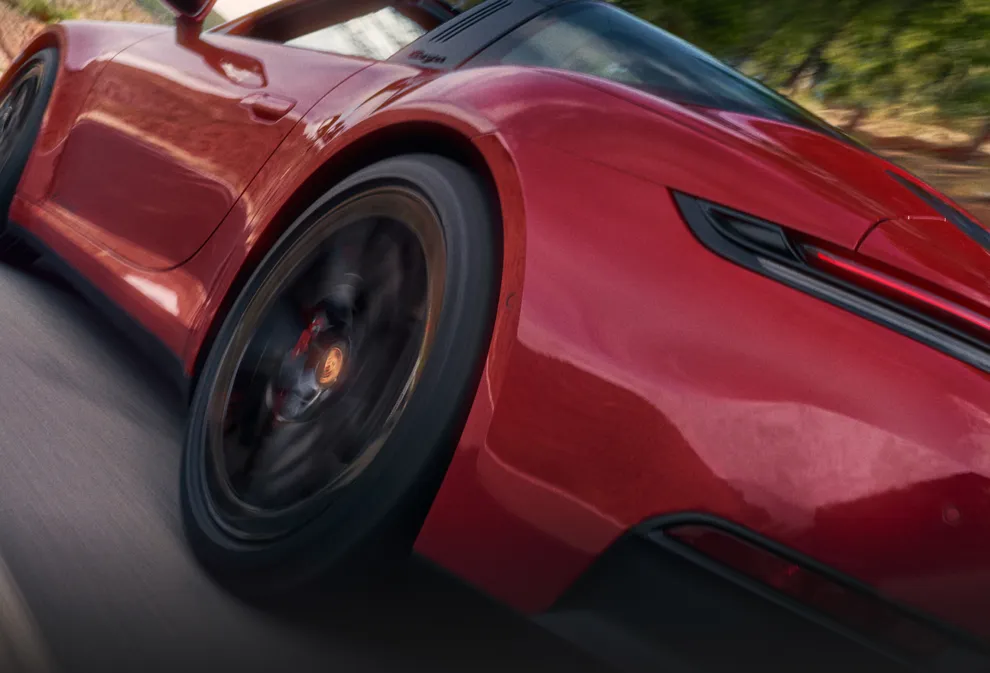 行驶于山路中的胭脂红保时捷 911 Targa 4 GTS 从后面看的侧后视图