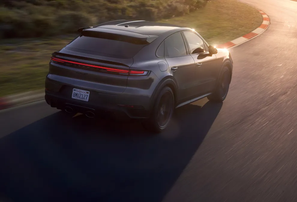 Porsche Cayenne Turbo GT in Quartzite Grey Metallic driving on the circuit track. Rear and side view.