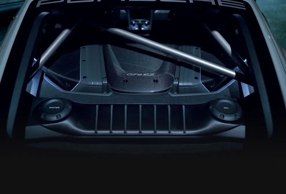 Detailed view of the airbox in carbon-weave finish on the Porsche 718 Cayman GT4 RS in Arctic Grey with Weissach Package.