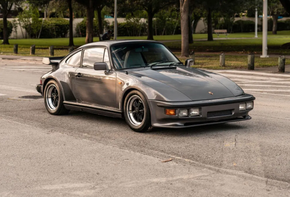 一辆 1982 年产特殊扁平车头的保时捷 911 Turbo 停在公园前 