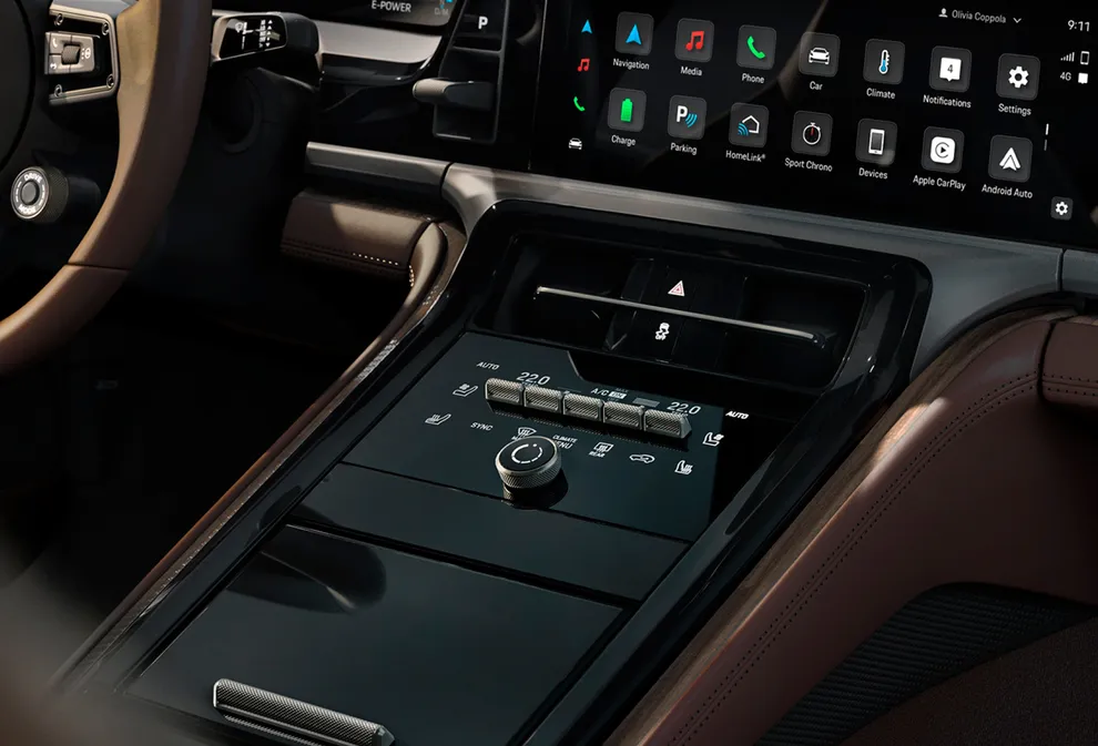 Porsche Panamera Turbo E-Hybrid Executive interior: detailed view of the centre console with climate control and charging cradle for a mobile phone.