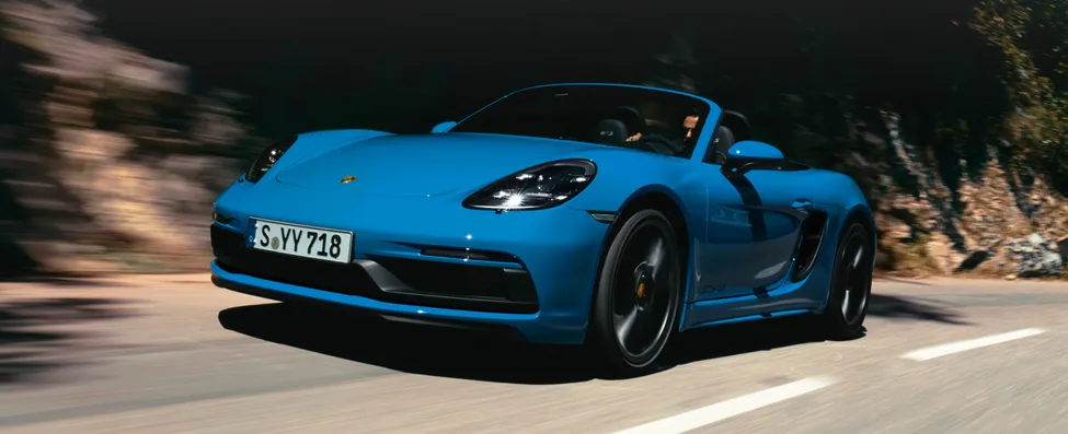 鲨蓝保时捷 718 Boxster GTS 4.0 正面和侧面行驶图。