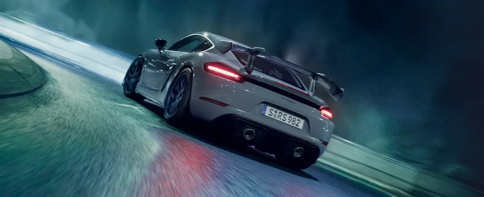 Porsche 718 Cayman GT4 RS in Arktikgrau mit Weissach-Paket fährt durch Tunnel. Blick aufs Heck.