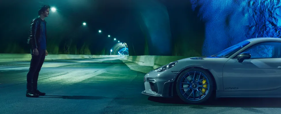 Porsche 718 Cayman GT4 RS in Arctic Grey with Weissach Package in a tunnel. View from the side of the front.