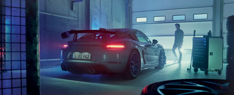 配备魏斯阿赫组件的极地灰保时捷 718 Cayman GT4 RS 停在车库中。尾灯开启时的后视图。