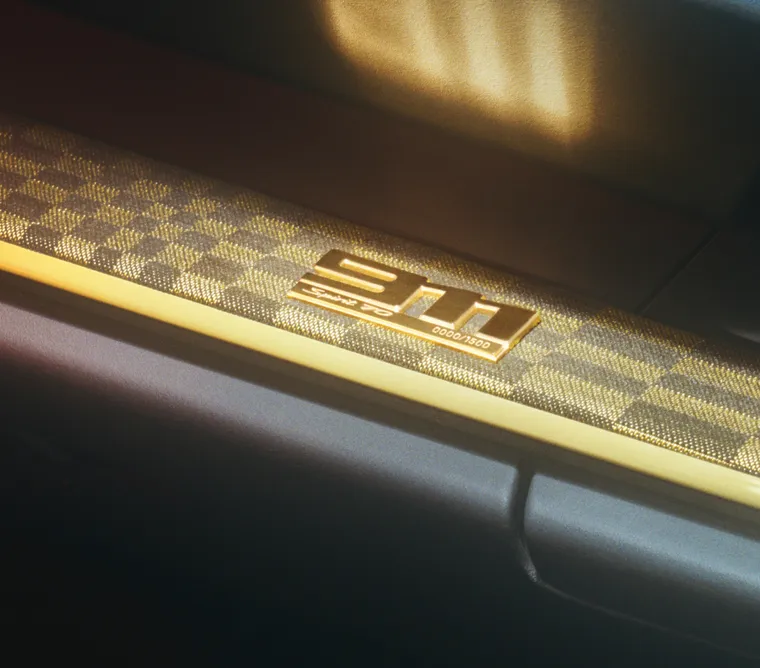 保时捷 911 Spirit 70 仪表板装饰件上带有 “911” 字样的金色限量版标牌细节图