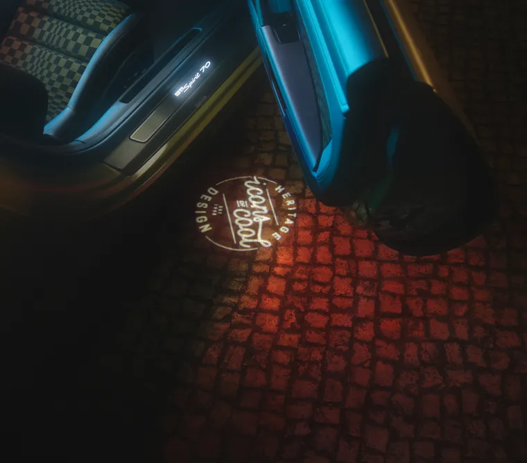 保时捷 911 Spirit 70 的车门打开时，投射到地面上的 “Icons of Cool” 标志的俯视图