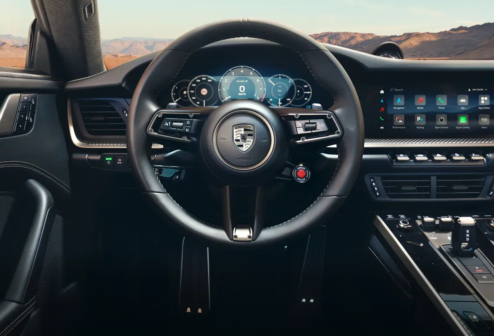 保时捷 911 Turbo S 上饰以 Turbonite 配色保时捷盾徽的 GT 运动型方向盘的细节图。