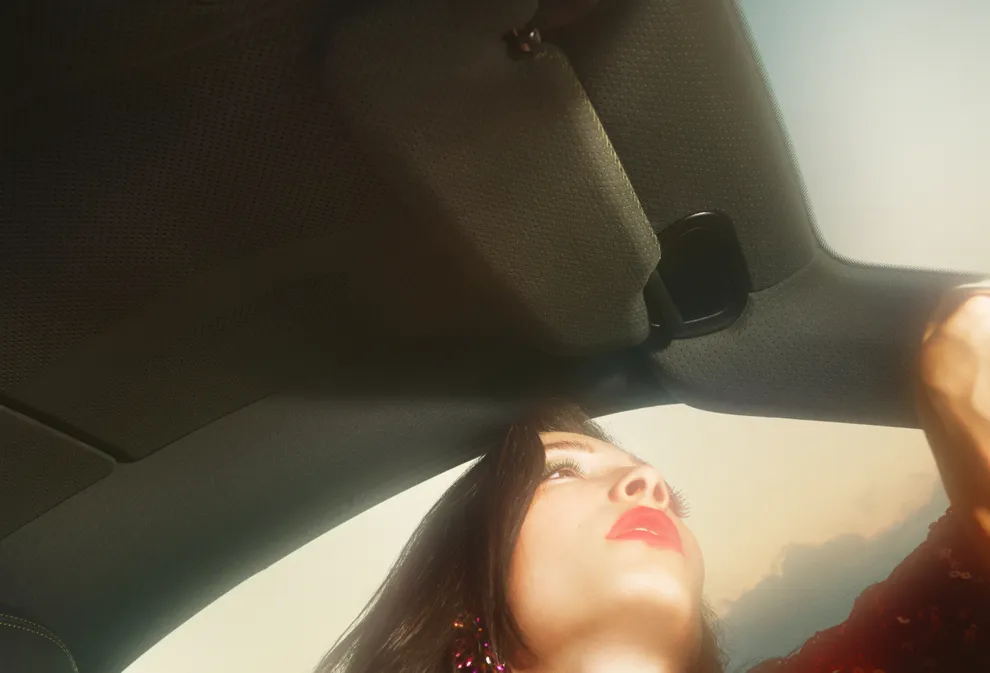 图中，一位红唇佳人的面庞与保时捷 911 Spirit 70 的 Race-Tex 面料车顶衬里交相辉映。