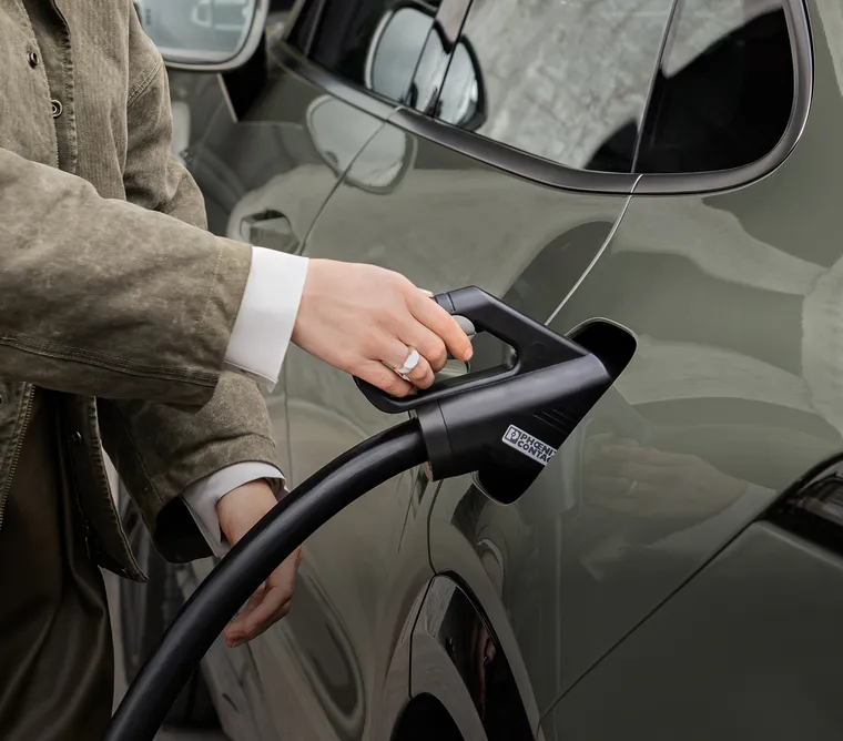 A Porsche Cayenne Turbo Coupé being charged at a charging pedestal.