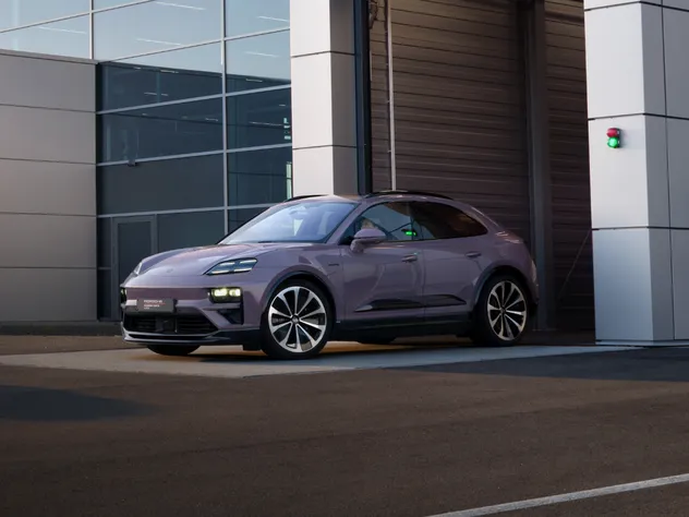 Porsche Macan 4 in Provence paint finish parked in front of the garage of a Porsche dealership.