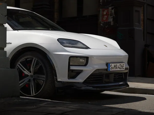 Blick von der Seite auf die Front eines Porsche Macan Turbo in Eisgraumetallic.