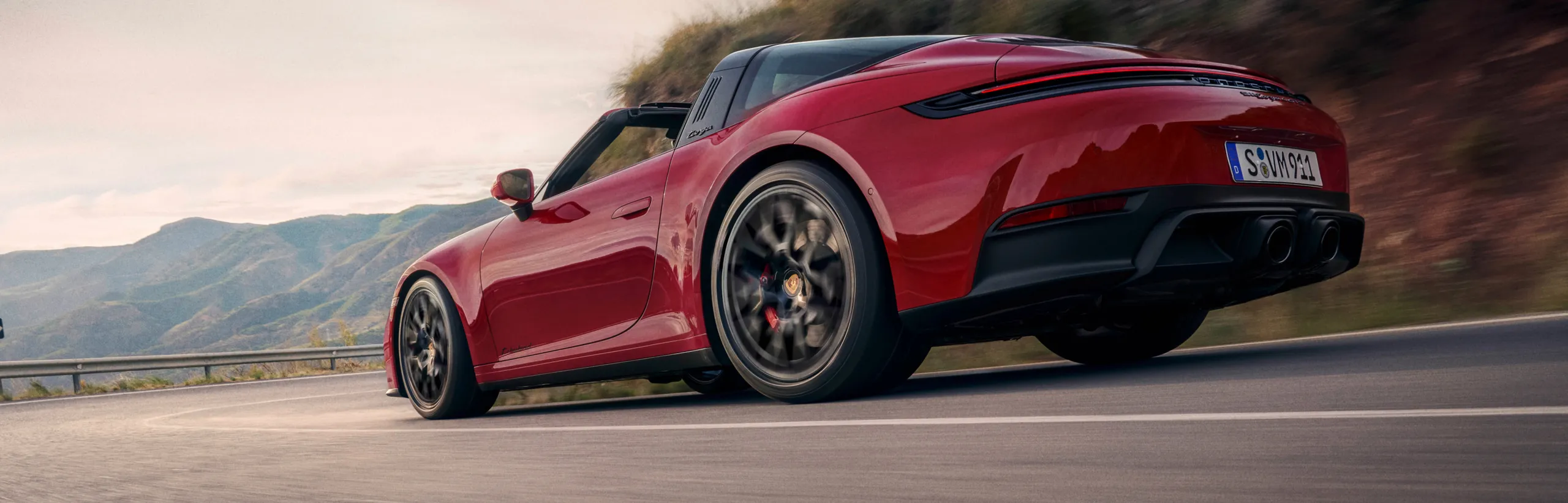 行驶于山路中的胭脂红保时捷 911 Targa 4 GTS 后侧视图