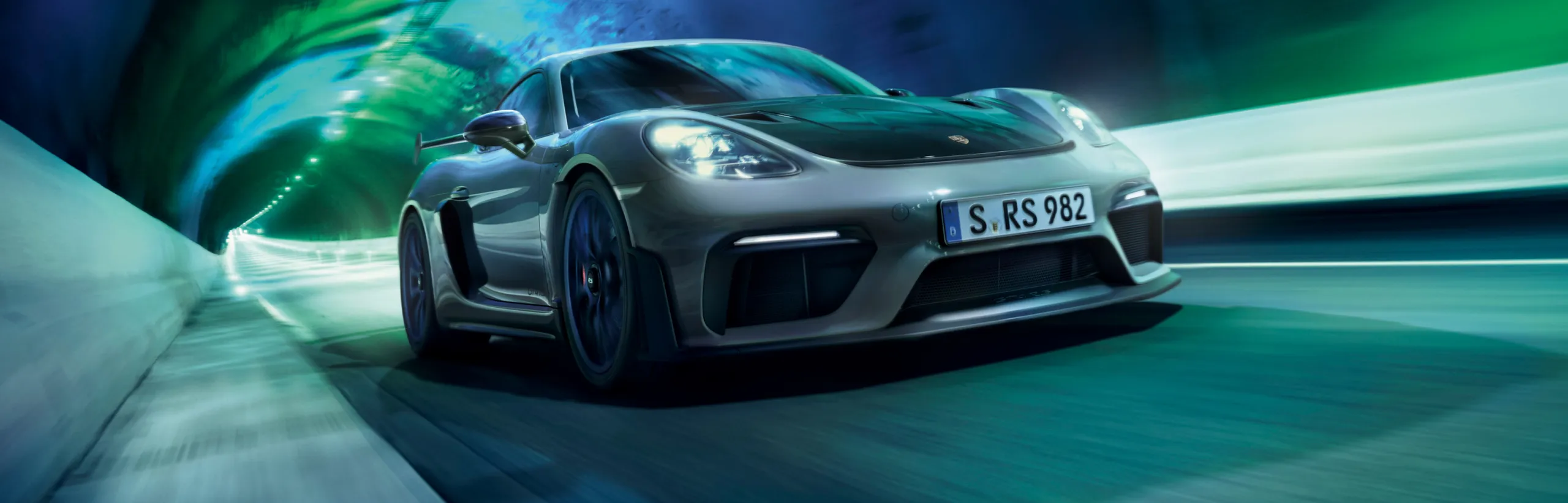 Porsche Cayman 718 GT4 RS in Arctic Grey with Weissach Package driving through tunnel. Front view.
