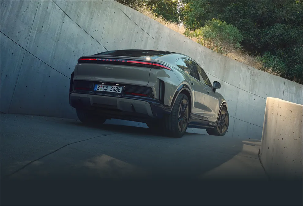 A Porsche Cayenne Turbo Coupé in Monteverde Metallic parking. View of the rear.