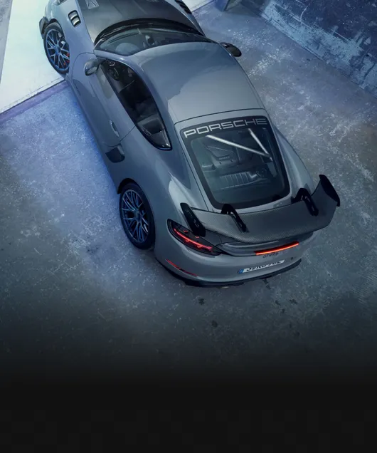Porsche 718 Cayman GT4 RS in Arktikgrau mit Weissach-Paket steht in Garage. Blick aus der Vogelperspektive auf das Dach.