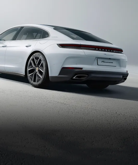 浅灰色背景下的细花白金属漆保时捷 Panamera 4 E-Hybrid 行政加长版从后面看的后侧视图