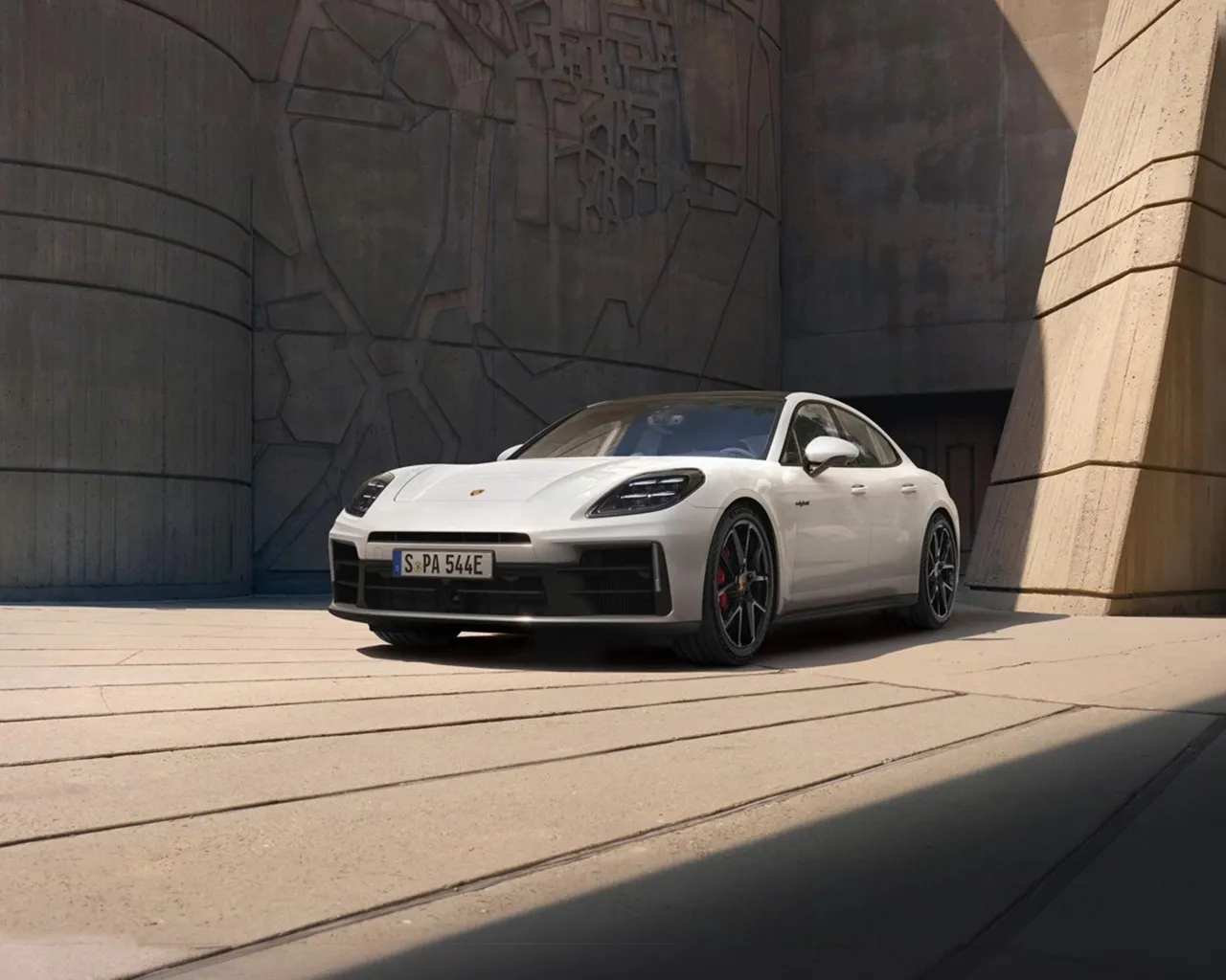 一辆保时捷 Panamera 停在一座现代化建筑前。