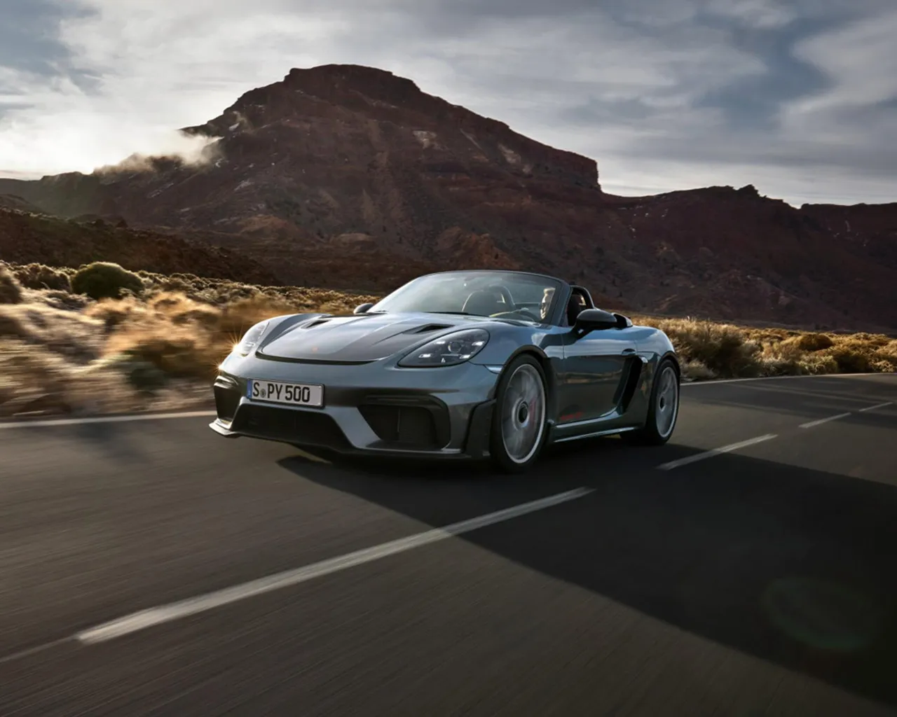 保时捷 718 Spyder RS 在岩层间的公路上行驶。